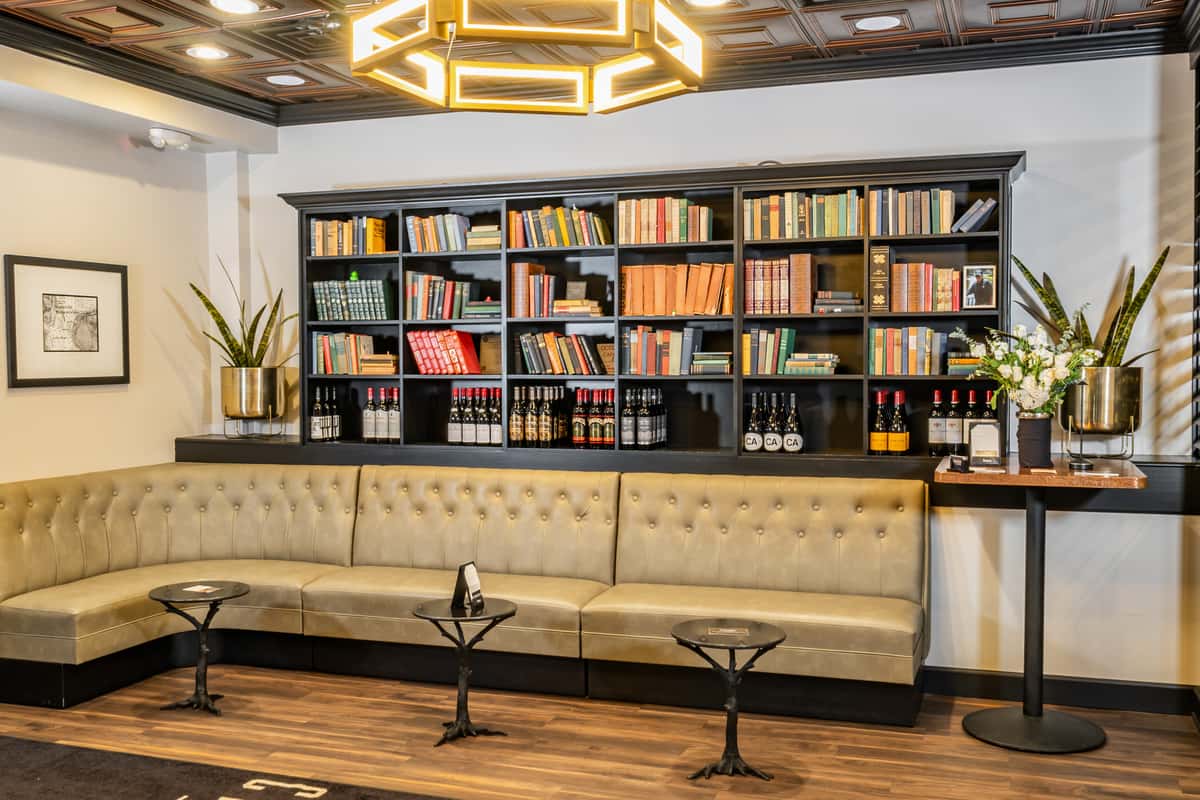 bookcase of books and bottles of wine