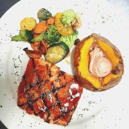 Grilled salmon with a side of mixed veggies and a baked sweet potato with butter.