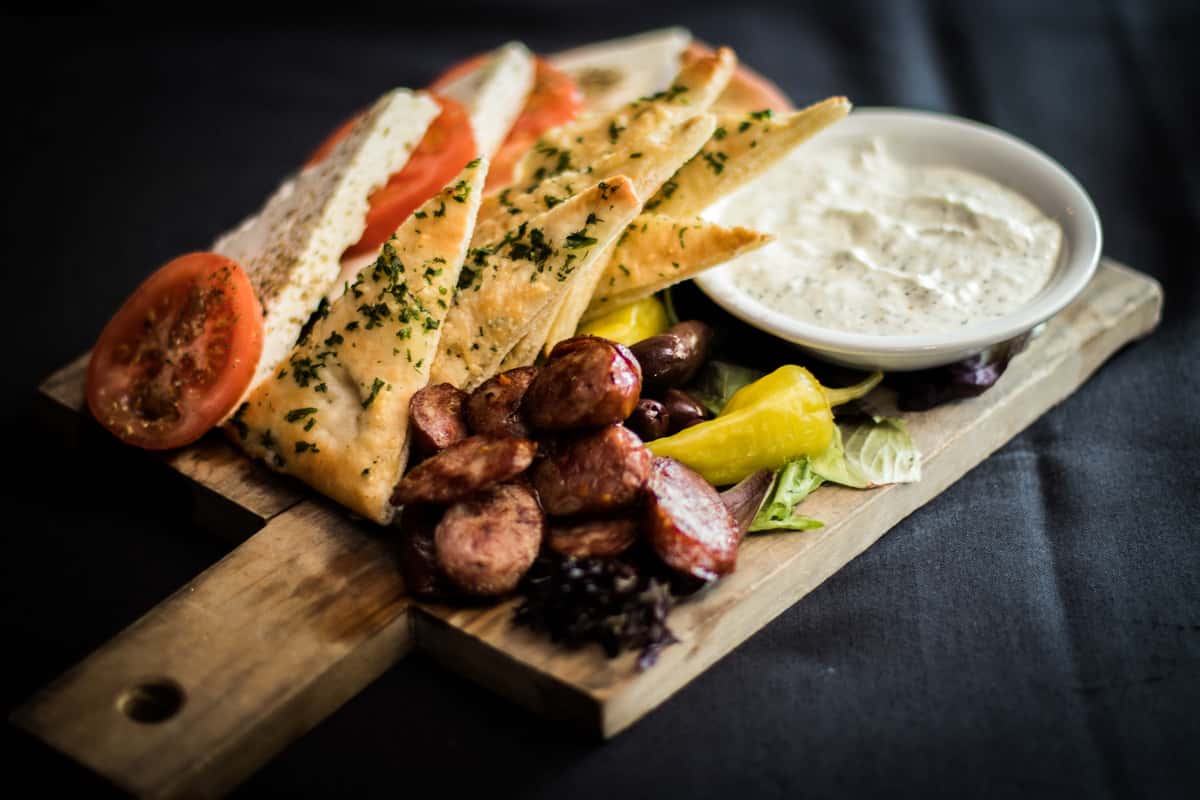 Wooden board with sauce and food
