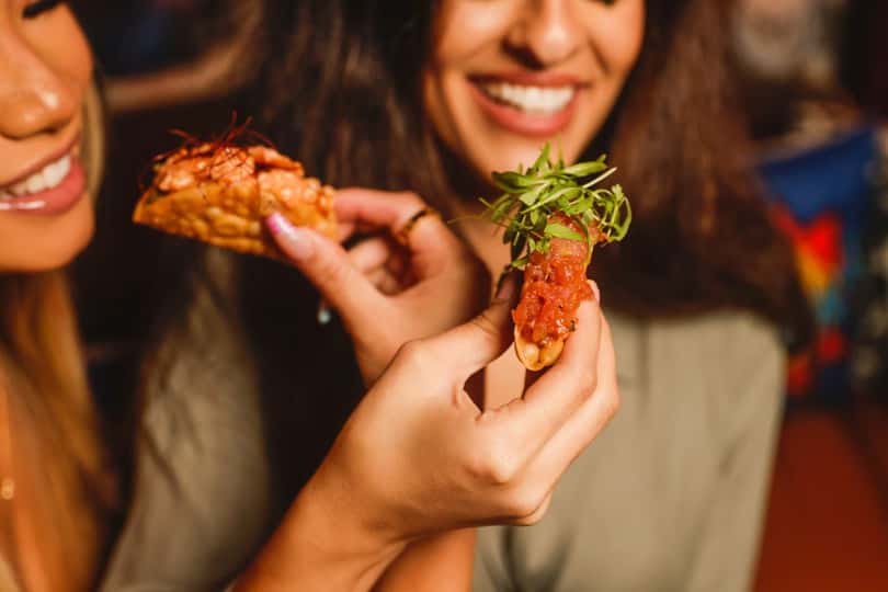Guests enjoying Asian fusion appetizers at Kapow! Noodle Bar, highlighting flavorful shareable plates, premium ingredients, and a vibrant social dining atmosphere.