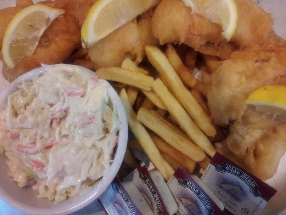 Fish and chips platter with lemon wedges and coleslaw