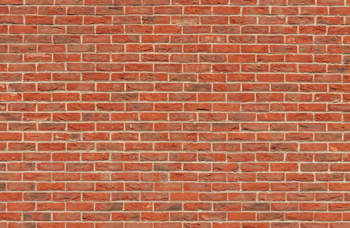 Red brick wall with a classic staggered pattern and visible mortar lines.