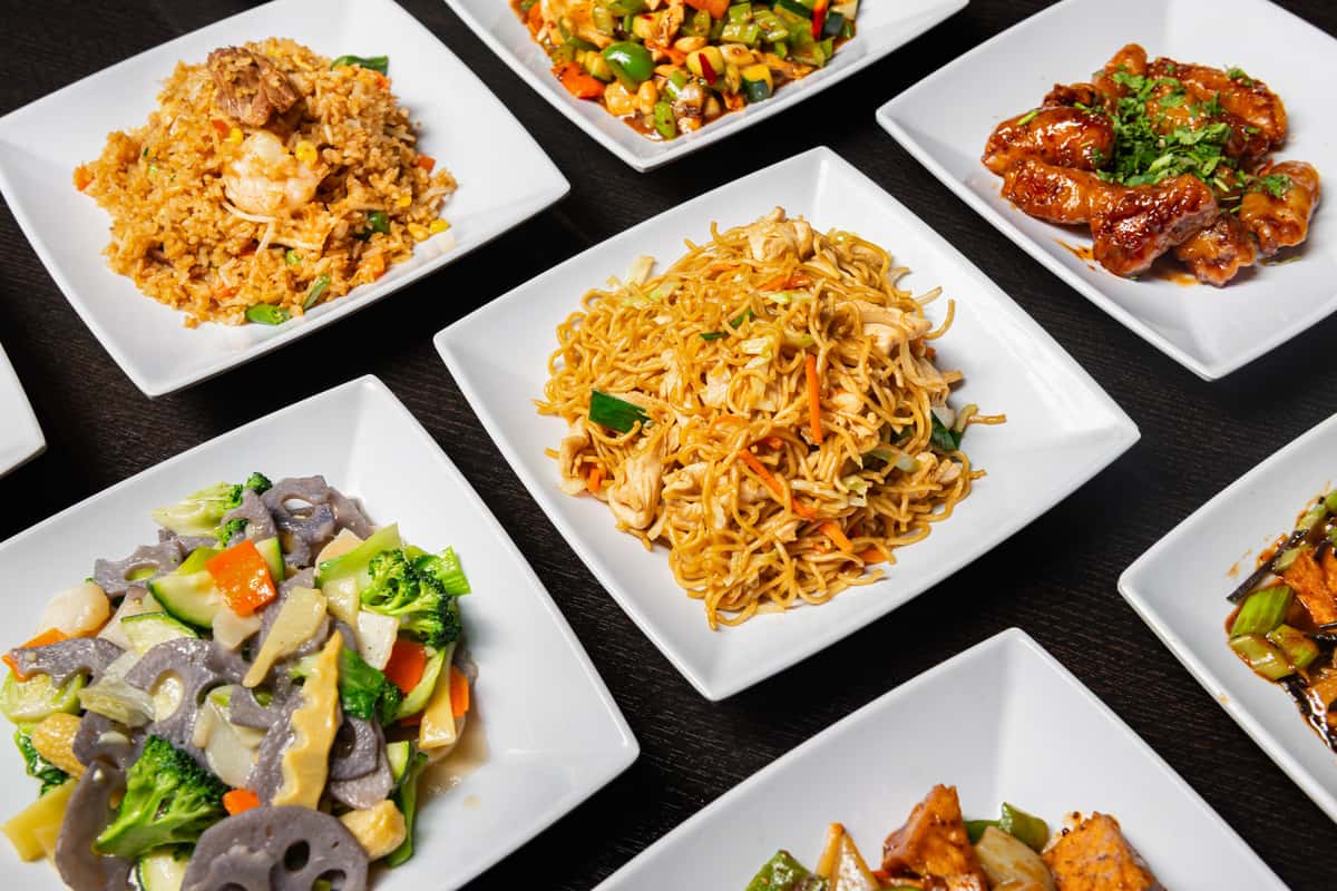 Group shot of dishes including noodles, chicken wings, chop suey, and more