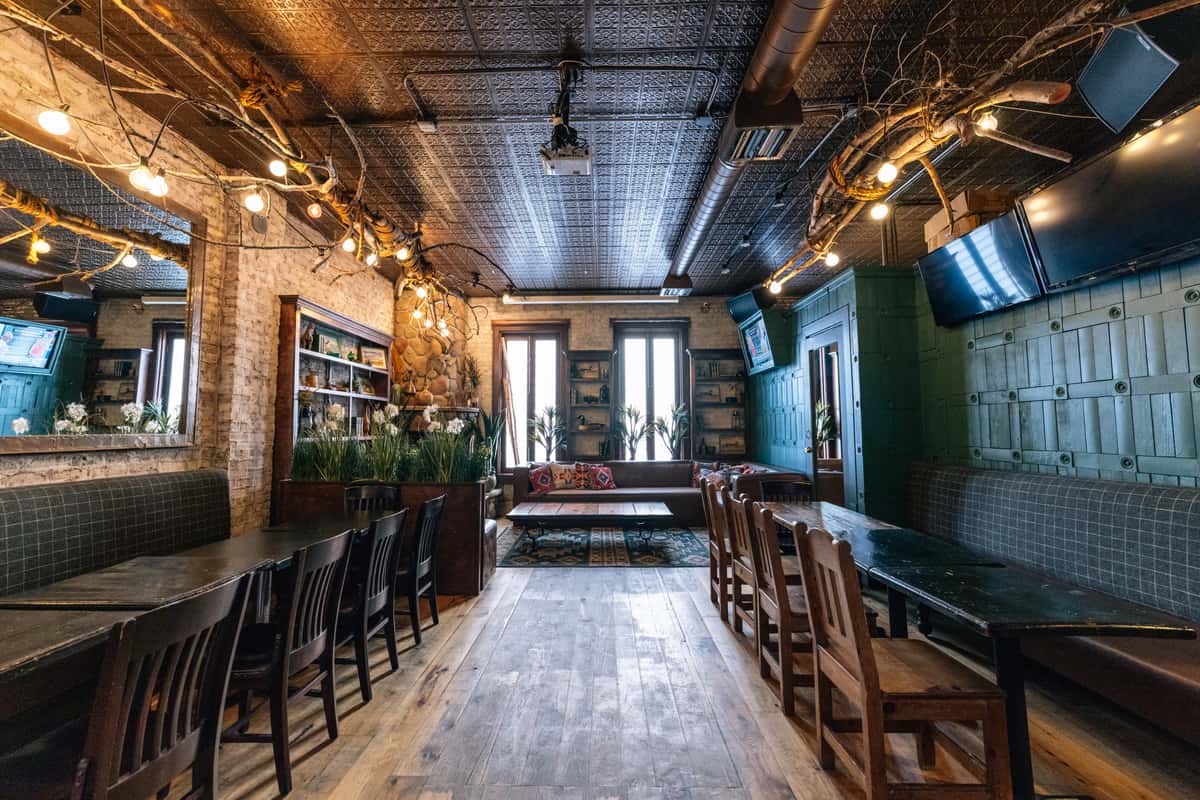 a cozily lit room with long tables on either side