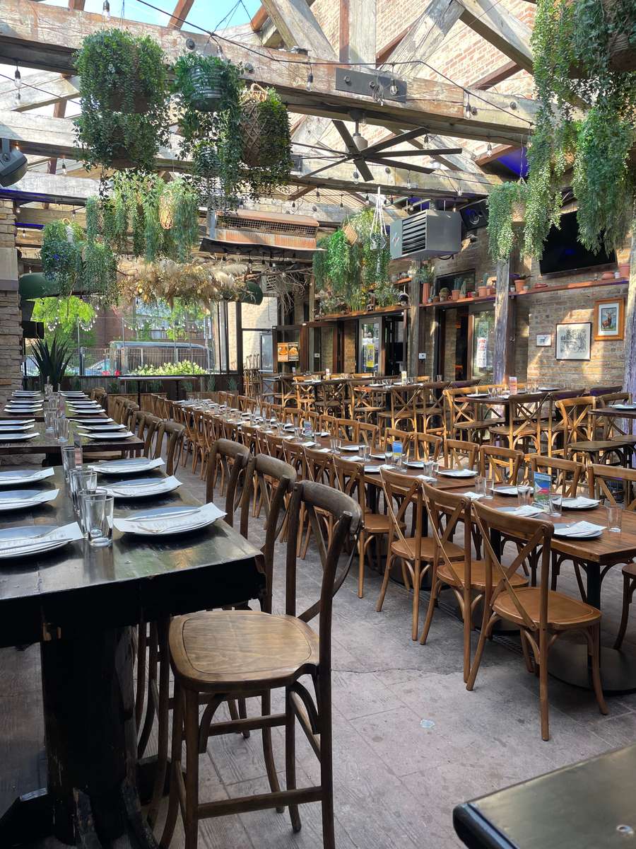 large party tables in our open air patio decorated with lush ferns and greenery