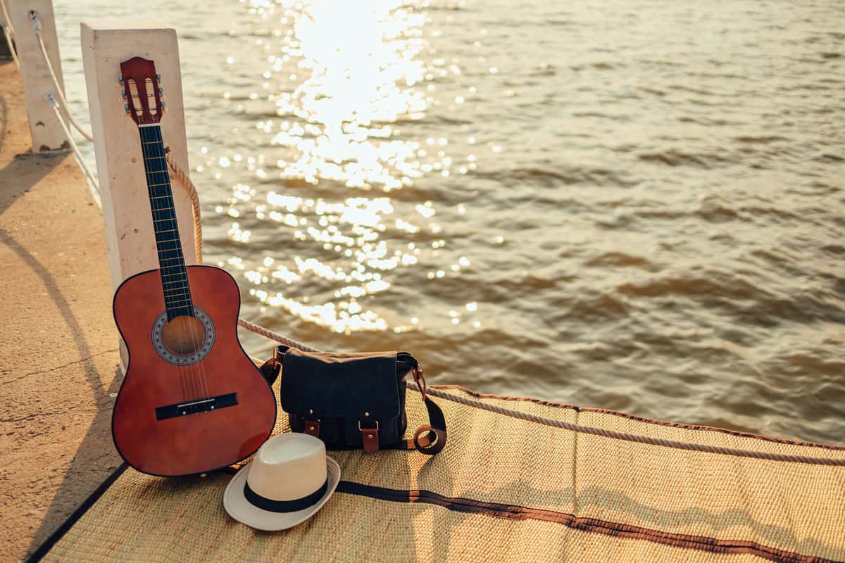 Hat and guitar by the sea