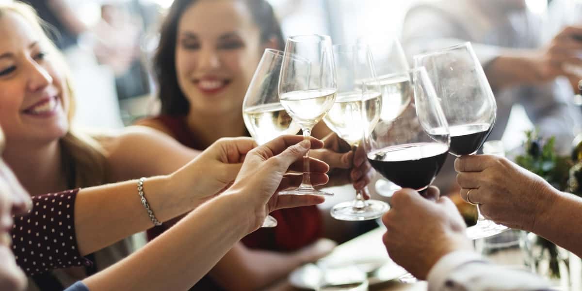 group of people touching wine glasses