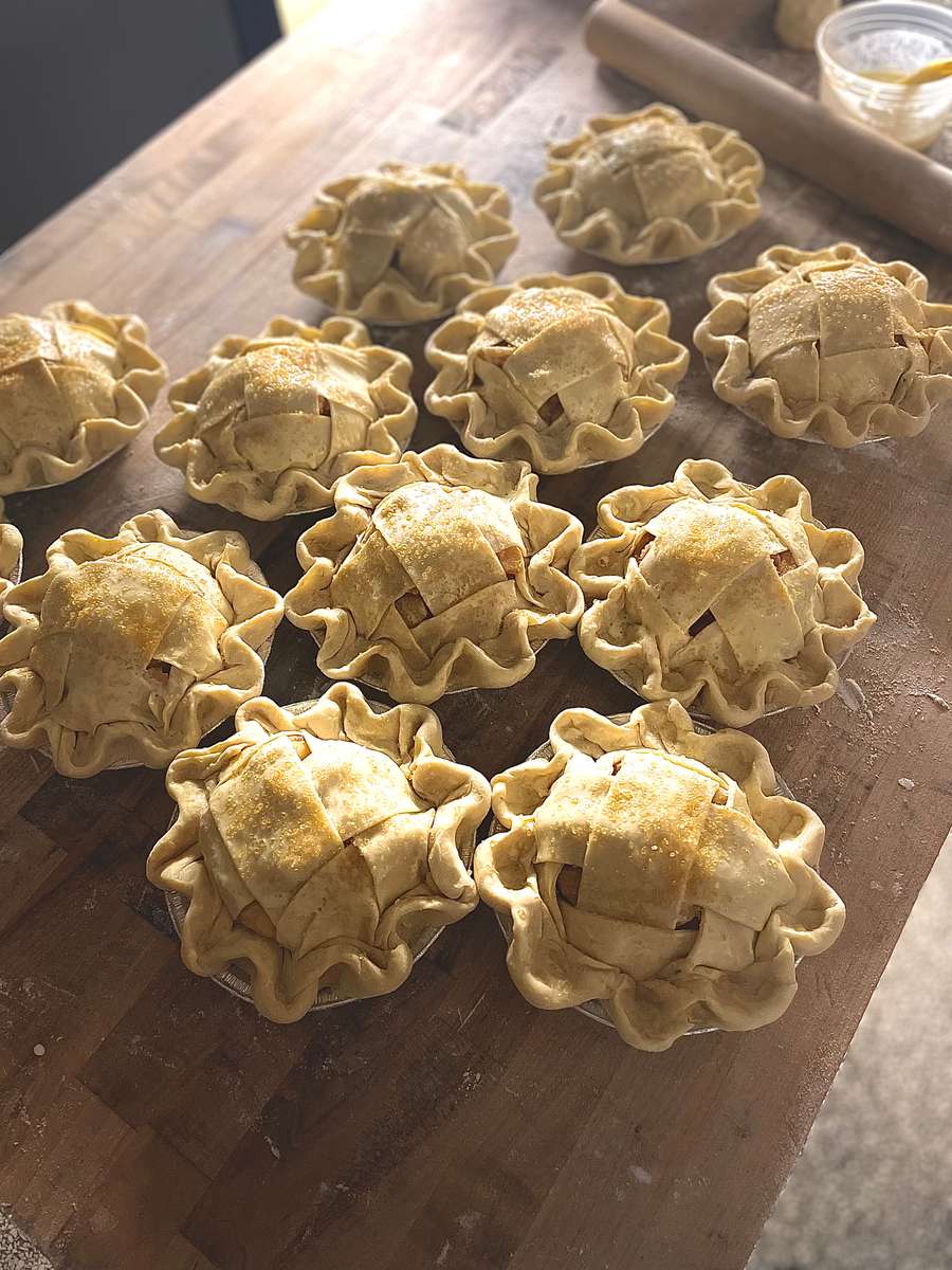 a table covered in mini apple pies before they are baked