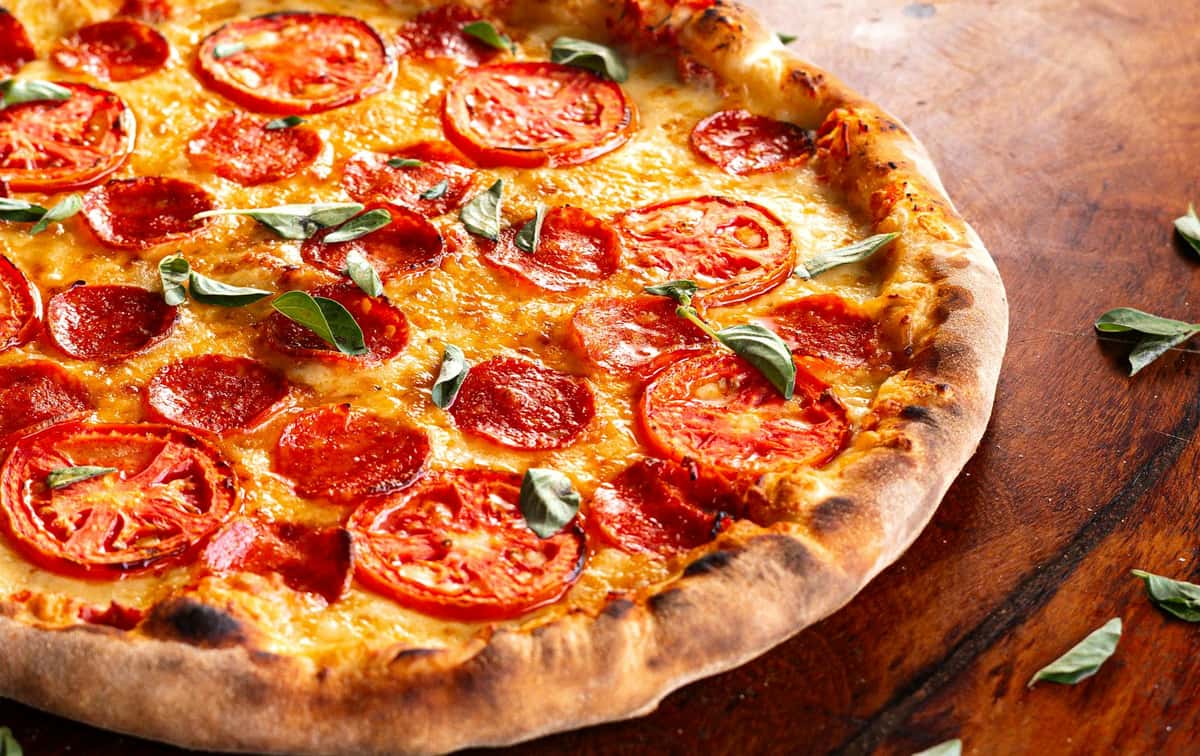 Close up of a pepperoni pizza on a wooden table