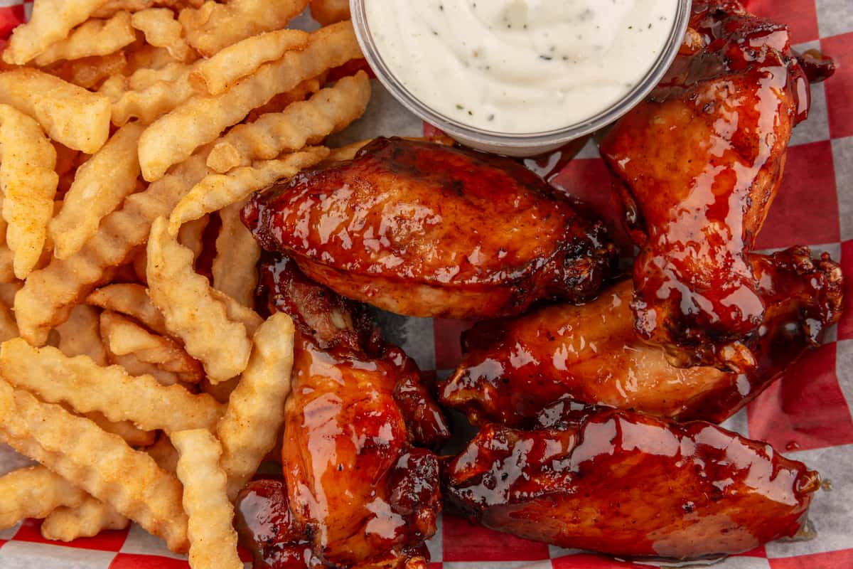 Crispy crinkle-cut fries served with glazed barbecue chicken wings and a cup of creamy ranch dipping sauce.