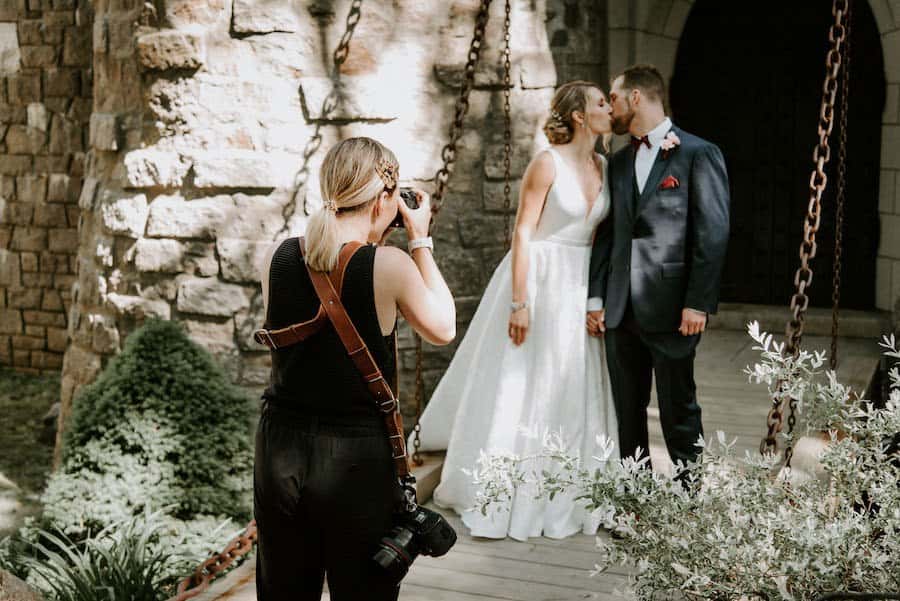 A photo of a wedding photographer working with a couple