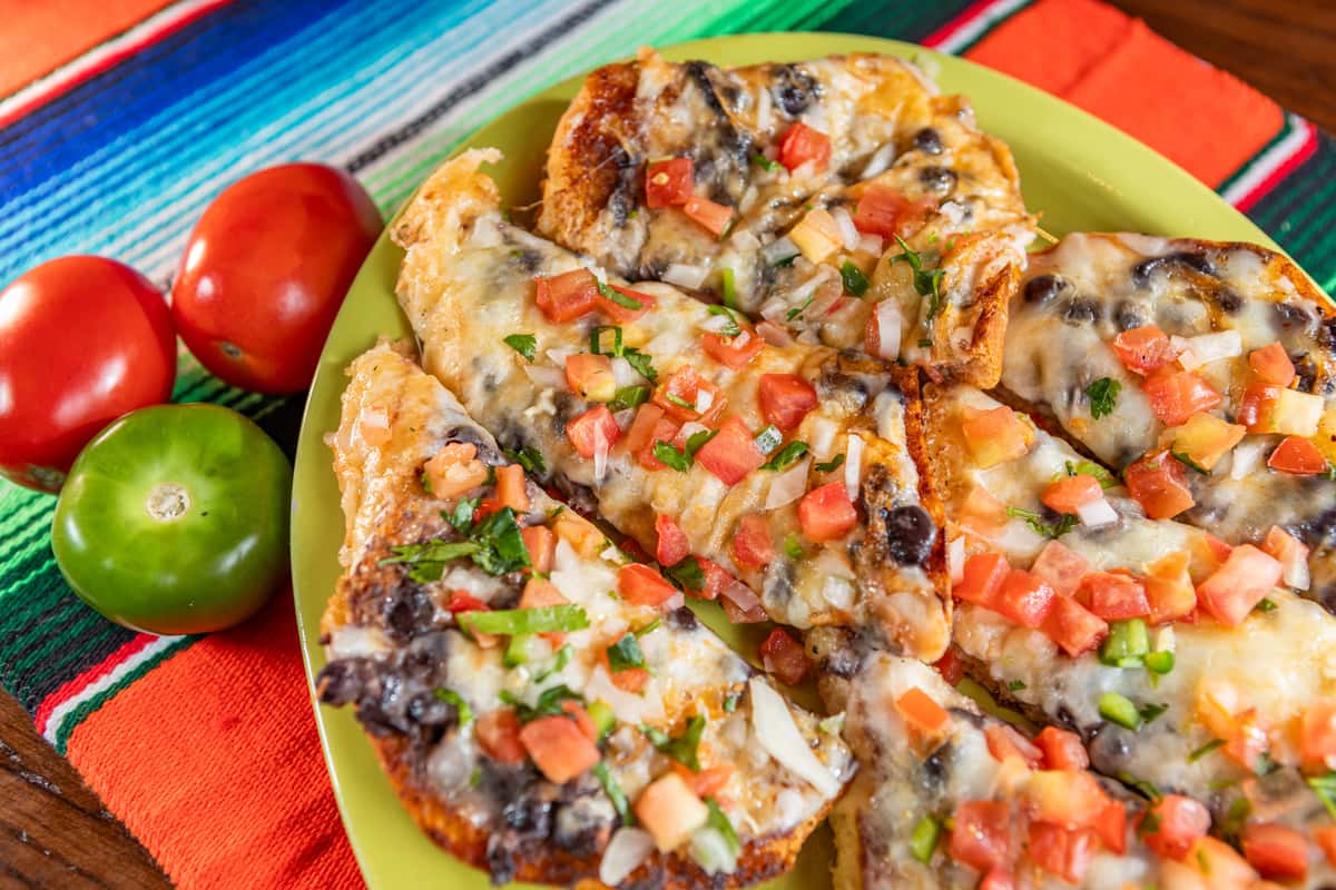 Cencalli Taqueria's cheesy black bean quesadillas with fresh pico de gallo, set on a vibrant Mexican blanket.
