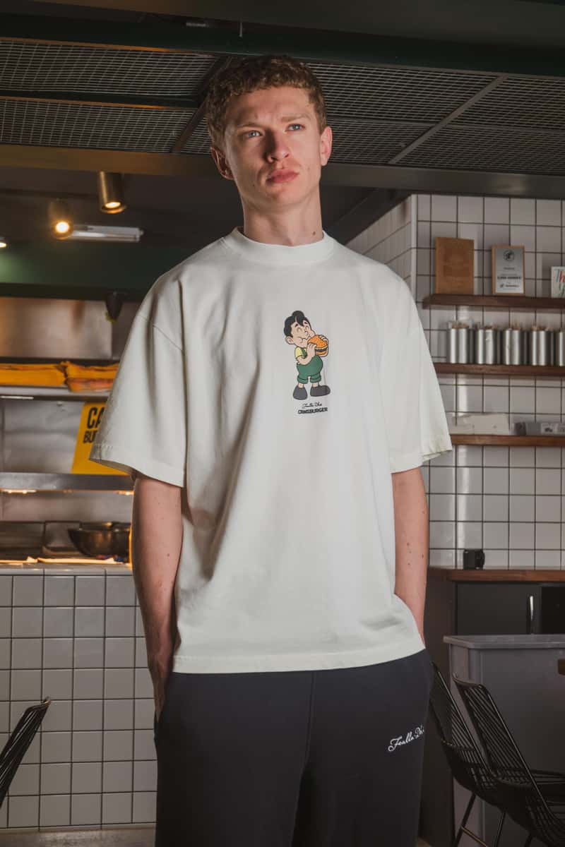 Limited edition Cawsburger x Fealla Dha collaboration t-shirt with illustrated burger graphic, worn in-store at Cawsburger.
