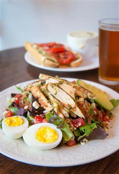 chicken cobb salad with a sandwich and beer