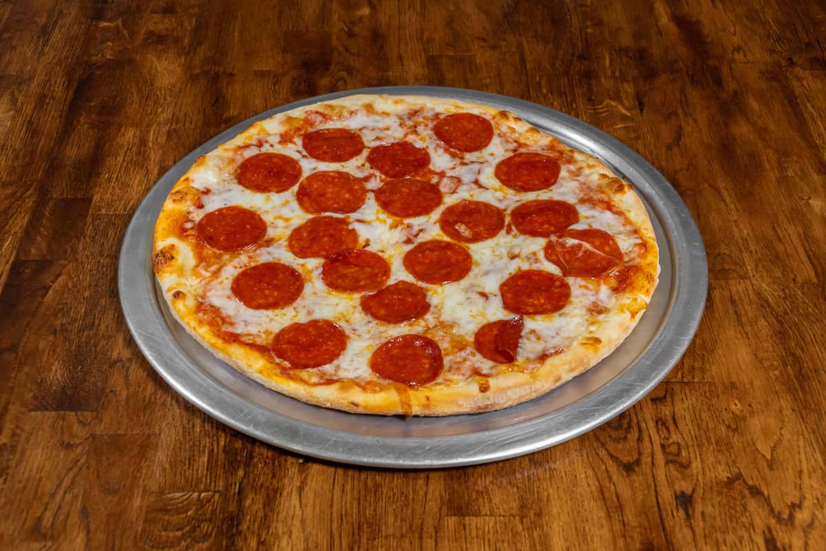 Classic pepperoni pizza with melted mozzarella cheese and tomato sauce on a hand-tossed crust, served on a silver pizza tray over a wooden table.