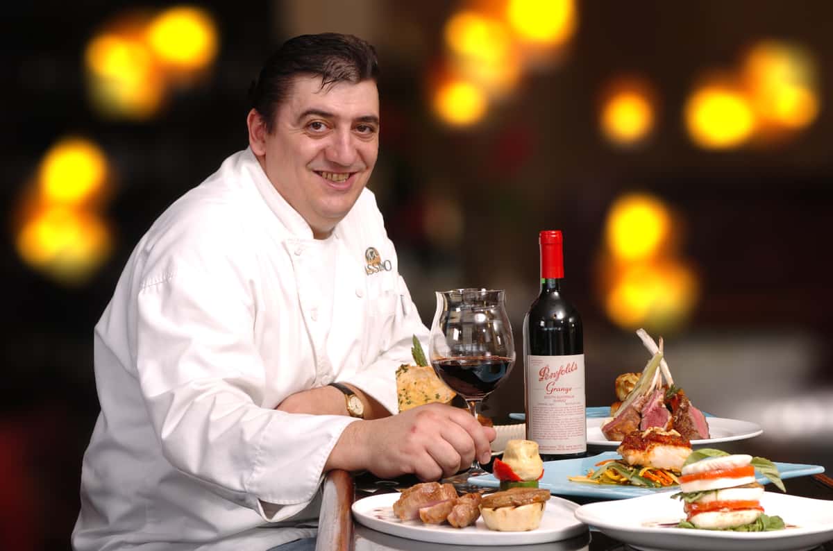 chef massimo at a table with various dishes and red wine