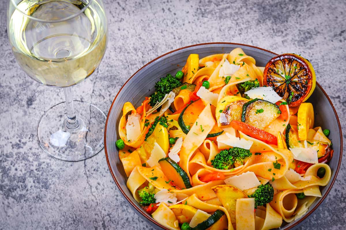 Pappardelle noodles, with zucchini, yellow squash, broccoli, green peas, roma tomatoes tossed in olive oli and vegetable broth, topped with shaved Parmesan