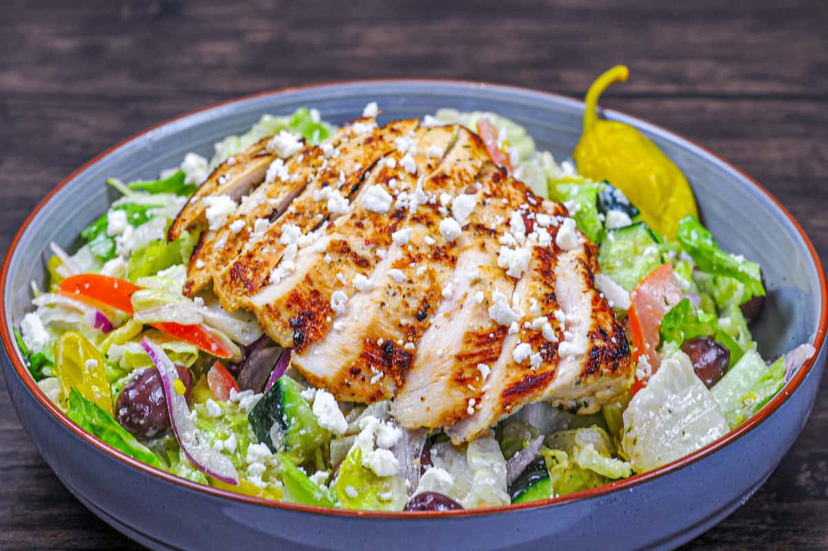 Grilled Greek marinated chicken atop romaine lettuce with cucumbers, red onions, Greek olives, tomatoes, pepperoncini and feta cheese with Greek dressing