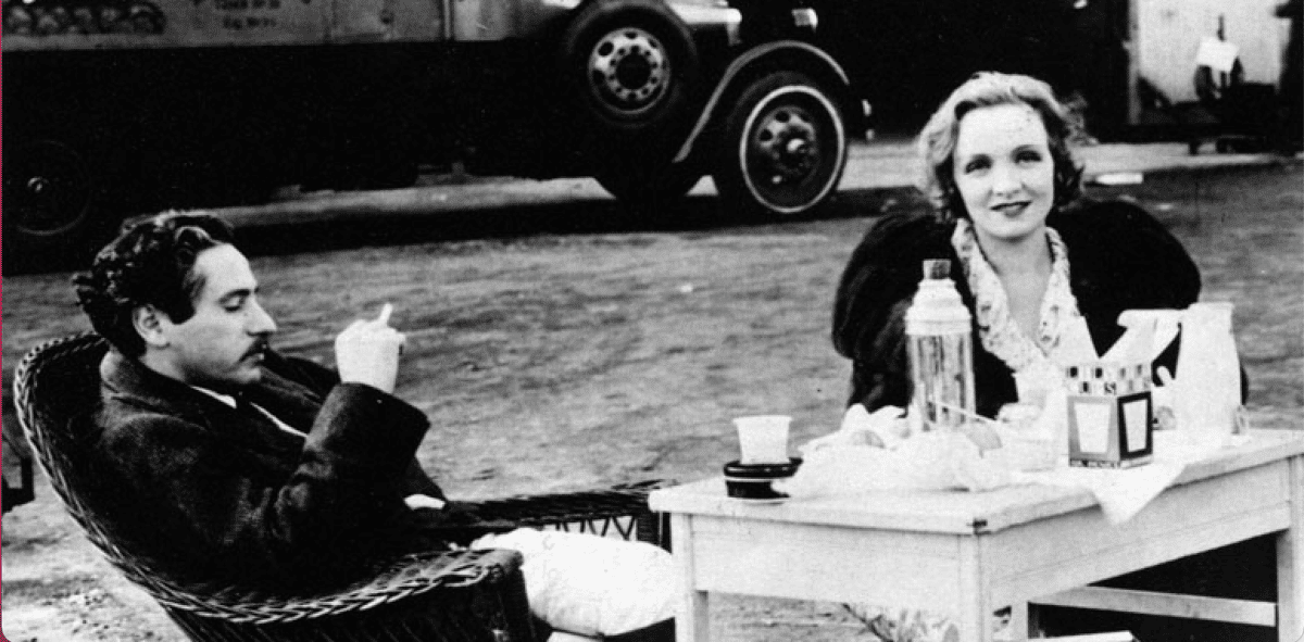 Marlene Dietrich sitting at table with thermos