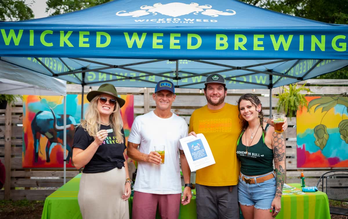 people standing in front of wicked weed brewing tent