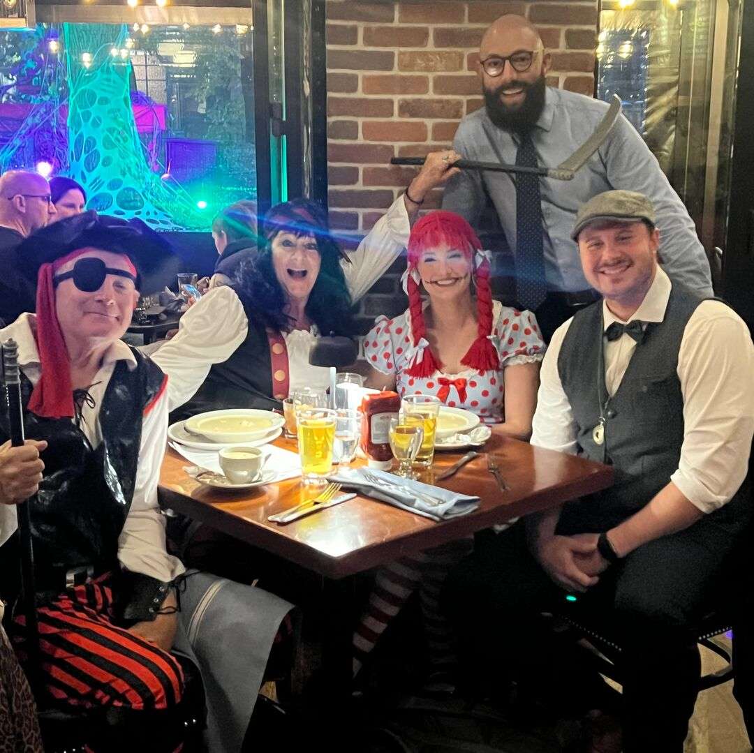 Customers in costume with restaurant manager Oscar