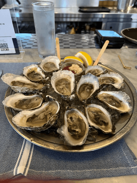 platter of a dozen shucked oysters on ice