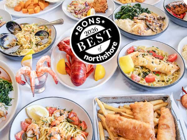 table full of seafood dishes including steamed lobster, fish & Chips, Haddock piccata and more