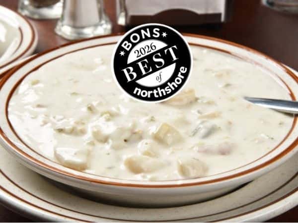 bowl of clam chowder on a table, with Best of Northshore logo