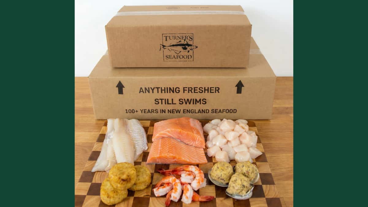 Boxes with fresh fish and prepared items; haddock, salmon, scallops, fish cakes, cocktail, stuffed clams; framed dark green on each side