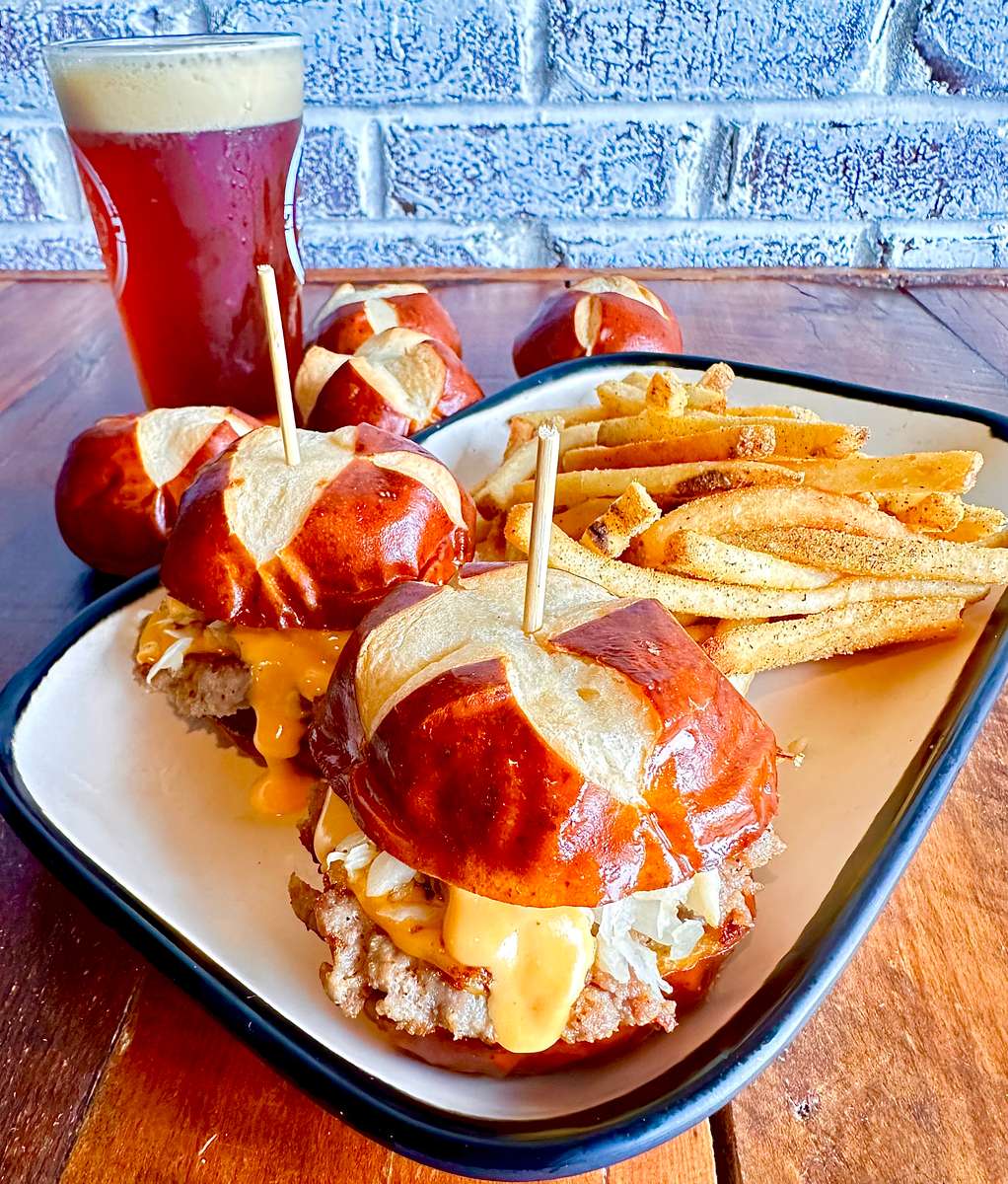 Two Krauss Meats Beer Bratwurst Sliders with American Cheese, Cleveland Sauerkraut, Brew Homemade Beer Cheese with choice of side.