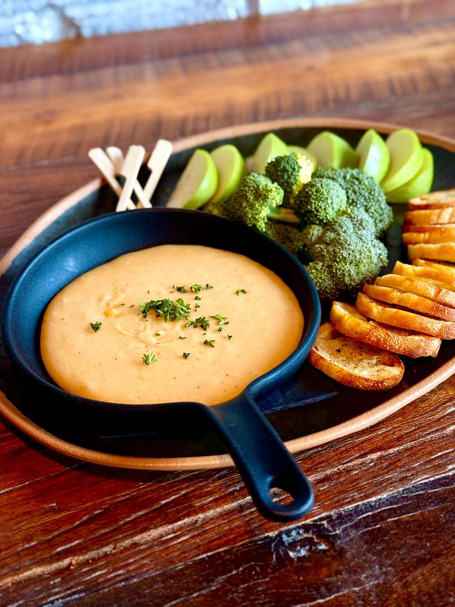 A rich and velvety blend of Fontina, Gruyère, and Smoked Gouda, melted together with white wine and nutmeg for a smooth, aromatic finish. Served with crisp green apple slices, toasted crostinis, and fresh broccoli florets for dipping.