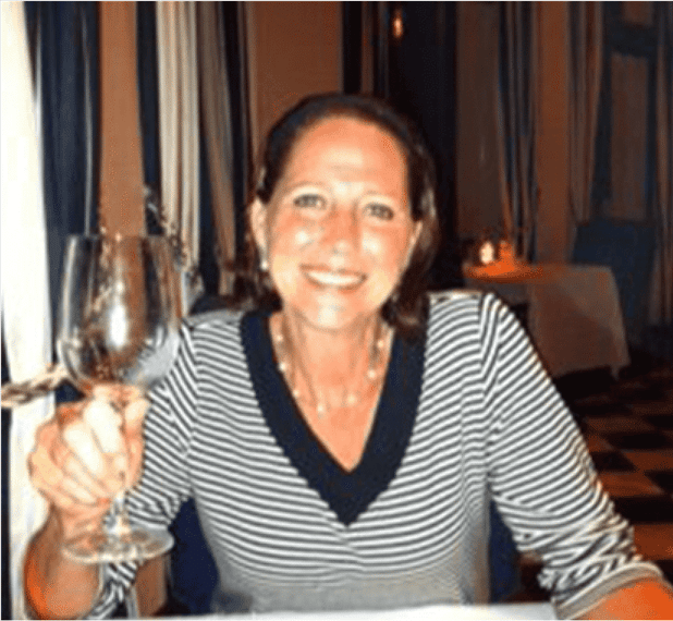 leah inside the restaurant holding up a glass of wine