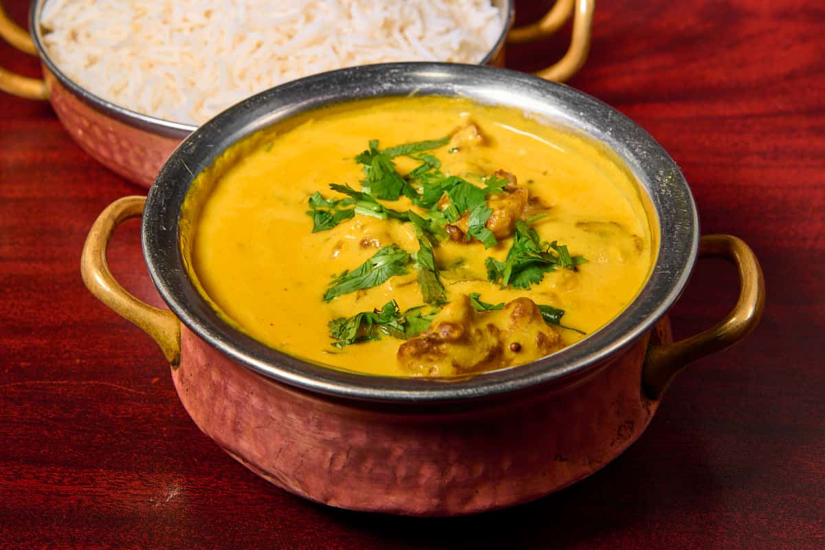 Punjabi kadhi chawal at Dhaba Express Parsippany NJ, creamy yogurt curry with pakoras served over rice with fresh herbs