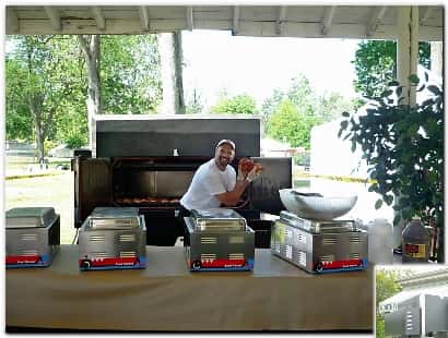 man posing for picture in front of a grill