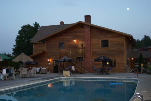 outdoor pool area with tables, chairs and umbrellas