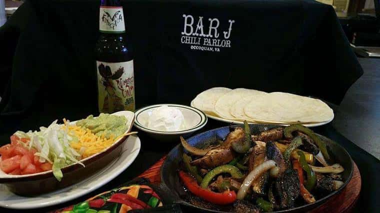 chicken fajita platter with tortillas and assorted toppings next to beverage