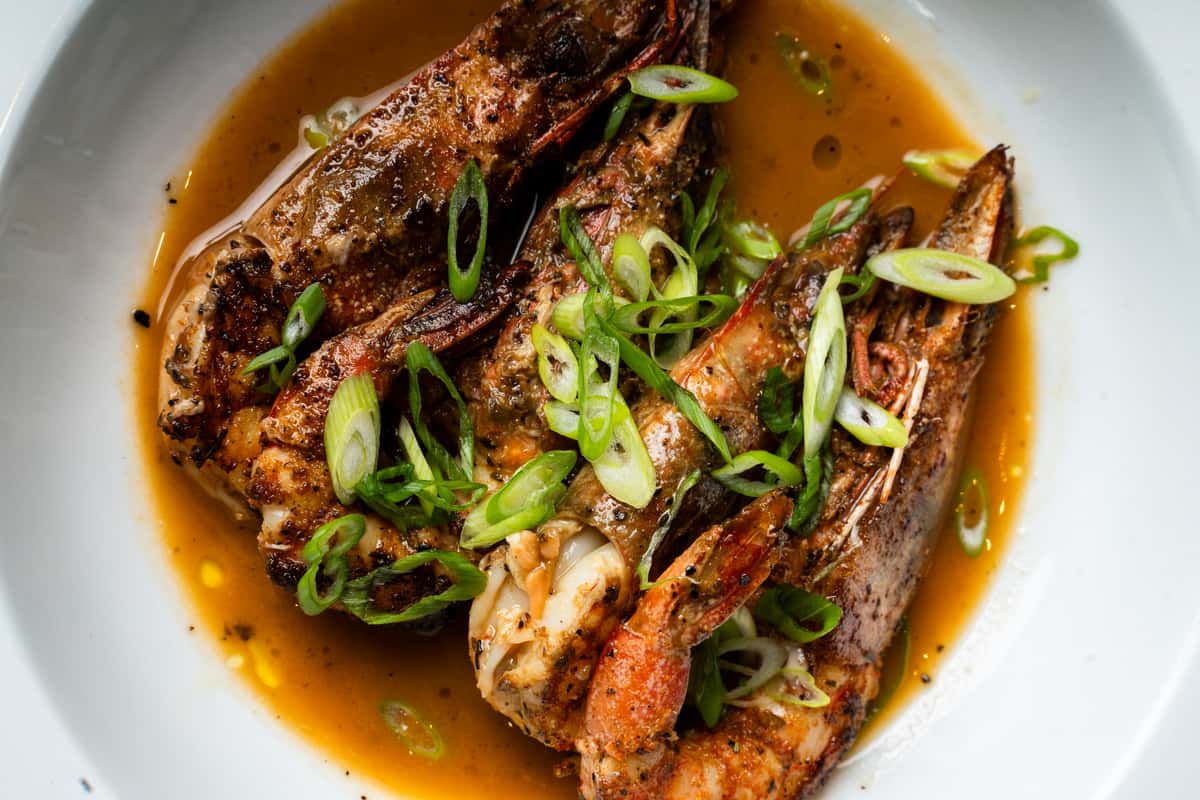 Cajun-style grilled shrimp served in savory broth with scallions at Oxford Place restaurant