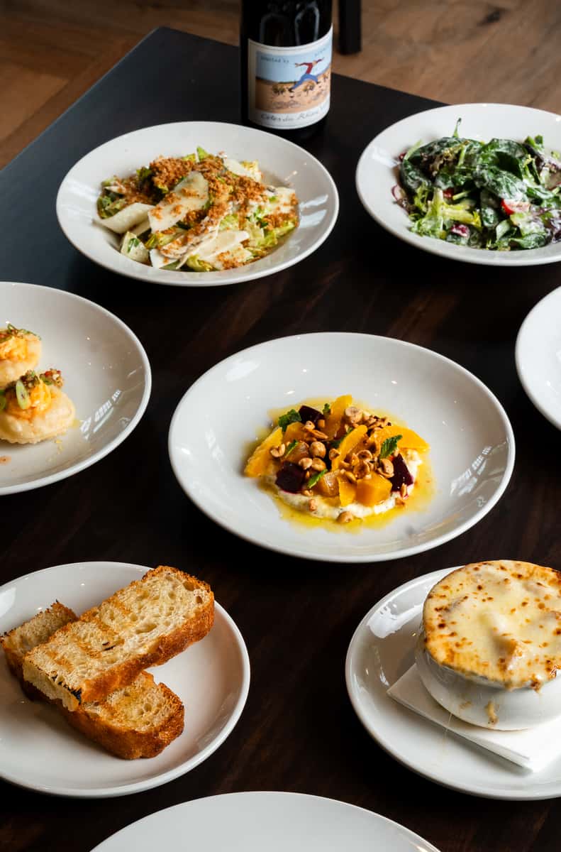 Southern-inspired shared plates and appetizers served on a dark wood dining table at Oxford Place