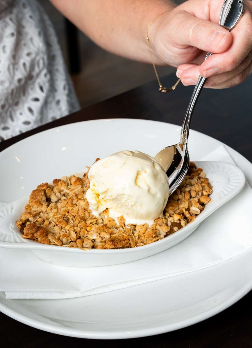 Warm fruit crumble dessert topped with vanilla ice cream at Oxford Place restaurant