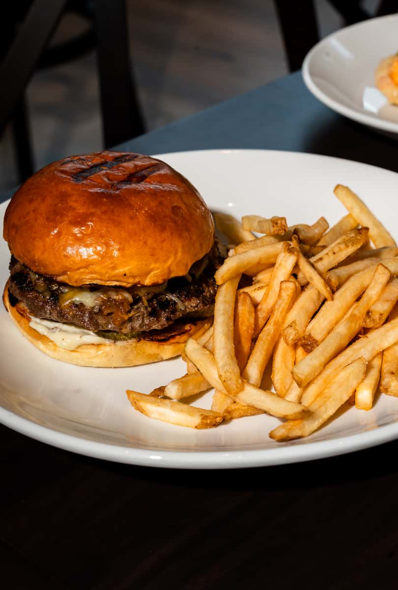 Restaurant-style cheeseburger with crispy fries served at Oxford Place neighborhood table