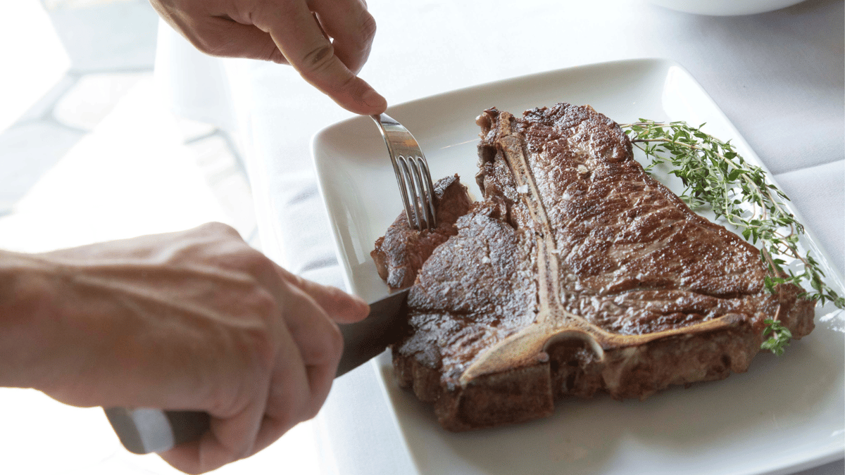 person cutting steak