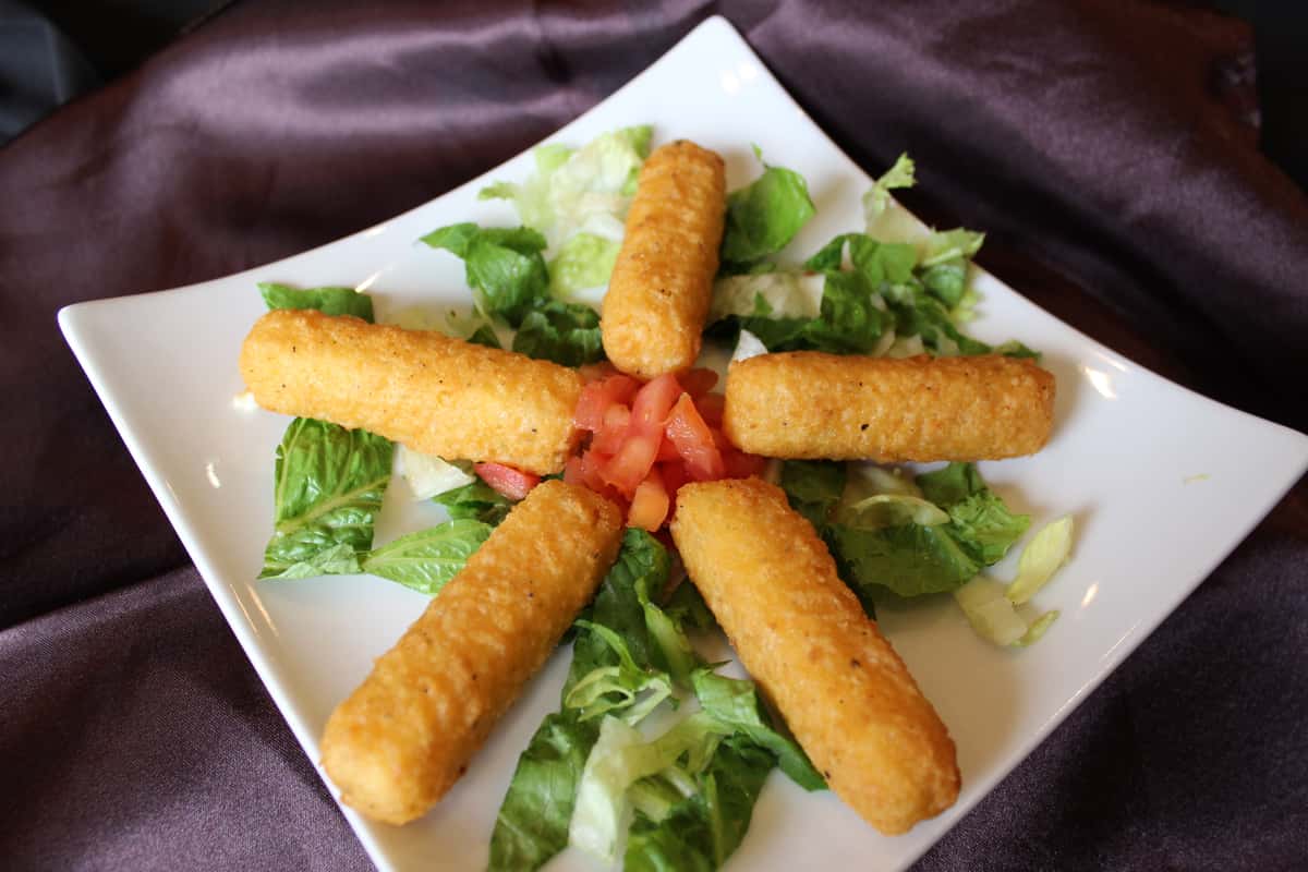 Golden fried mozzarella sticks served over a fresh garden salad