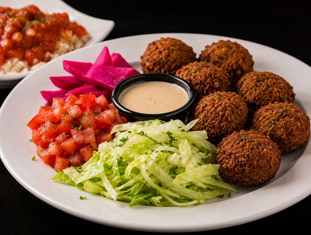 Falafel platter with pickled turnips, chopped salad, lettuce, and tahini sauce