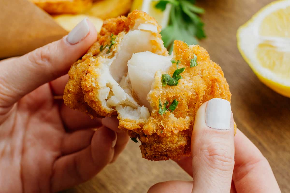 Woman's hands breaking piece from fish