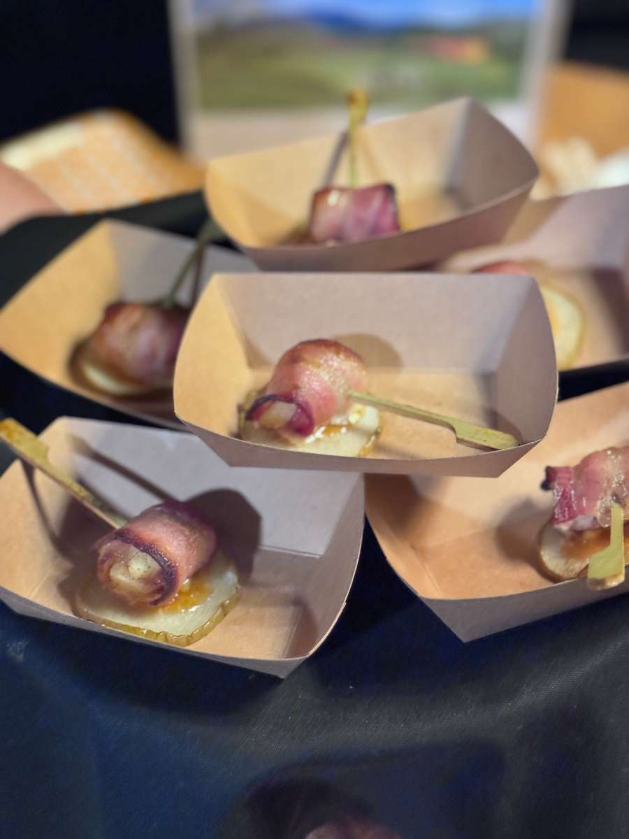 Savory bacon-wrapped appetizers served on skewers in individual tan paper boats at The Grove Cucina & Wine.