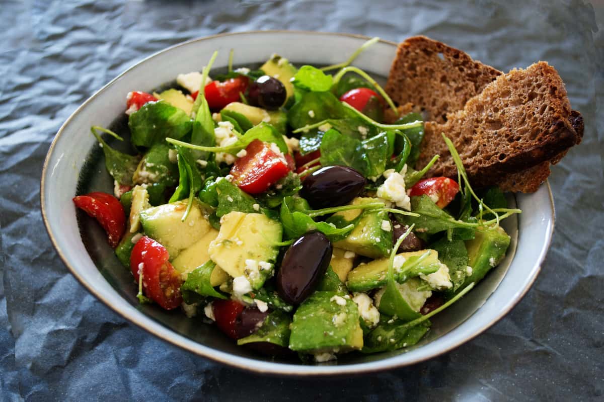 Salad with avocado, beans, tomatoes and bread