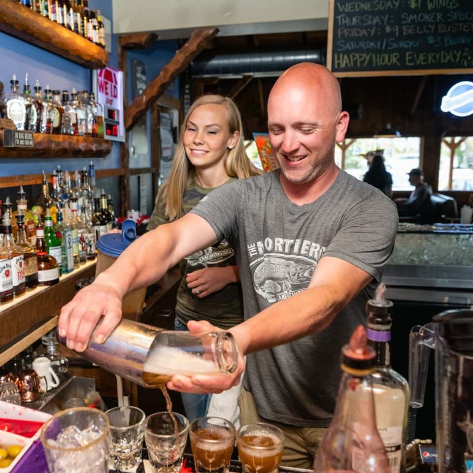 A bartender making a drink behind the bar