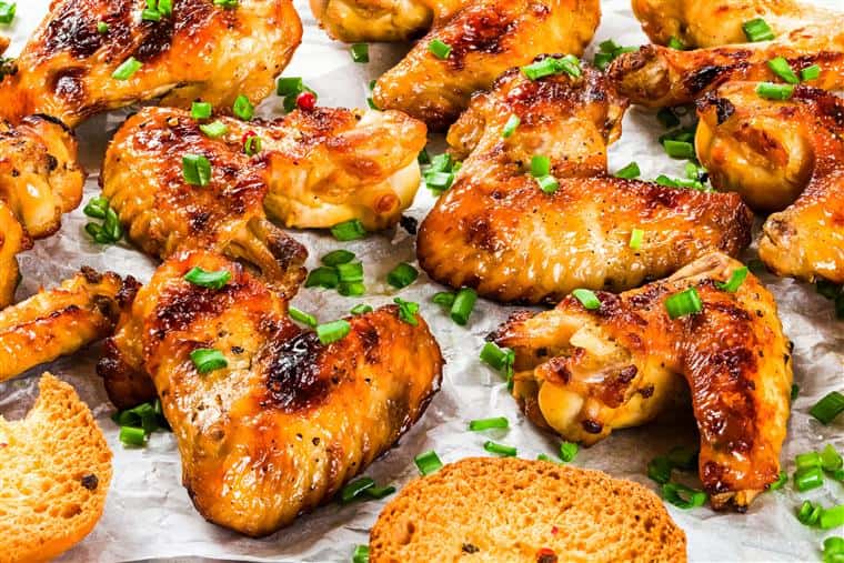 browned chicken wings topped with freshly chopped herbs