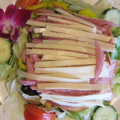 Salad with shredded cheese and cold cuts