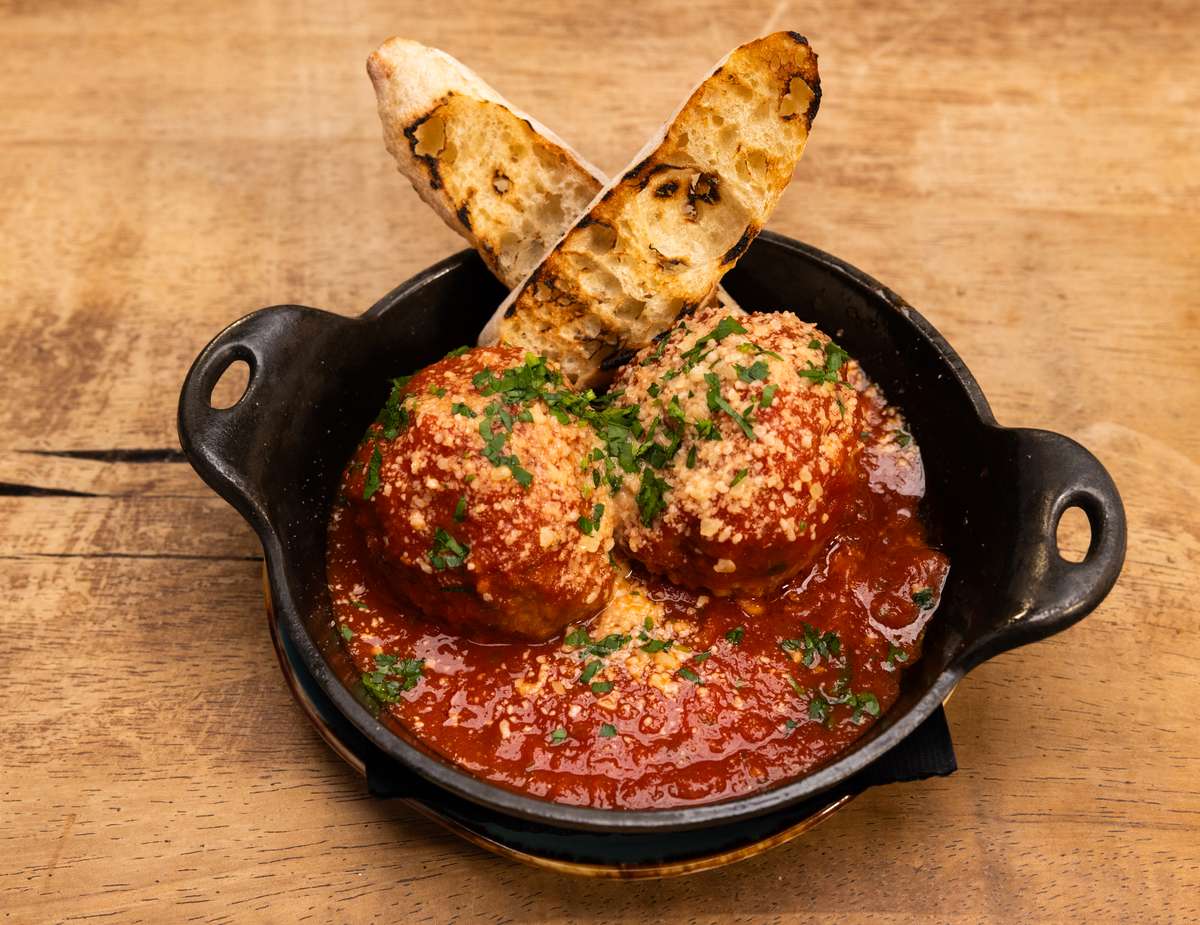 Meatballs in sauce with two bread sticks